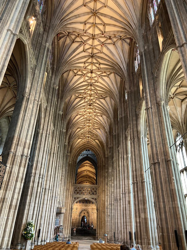 KI generiert: Das Bild zeigt das beeindruckende Innere einer großen Kathedrale mit einem hohen, gotischen Gewölbe und prächtigen, verzierten Säulen. Im Vordergrund sind hölzerne Kirchenbänke und im Hintergrund ein gut beleuchtetes Kirchenschiff sichtbar.